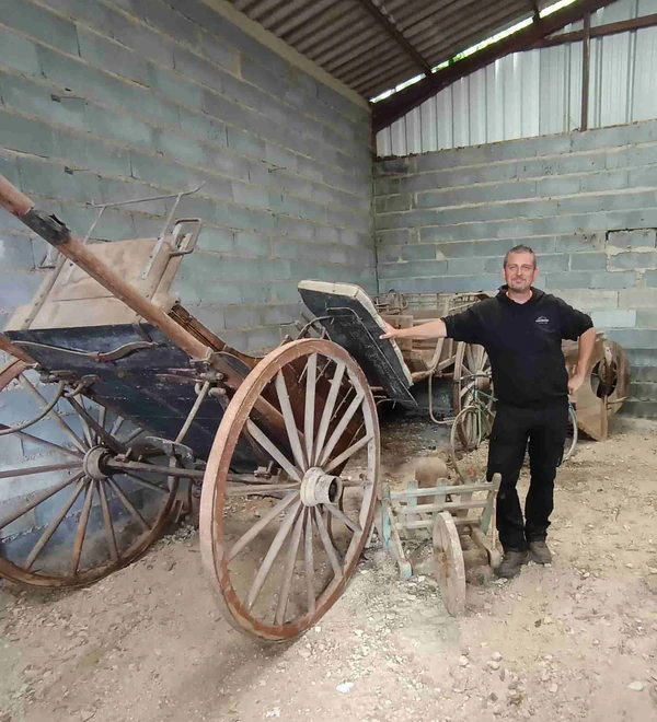 Anthony Casano dans un hangar rempli de matériel ancien